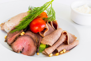 Marble cutting board with prosciutto, bacon, salami and sausages on wooden background. Meat platter
