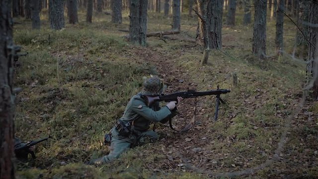 Historical Reconstruction Of The Second World War. A fascist sniper soldier in a trench with a machine gun takes aim to kill the enemy