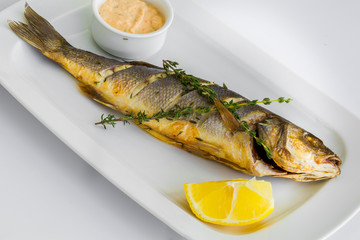 baked sibas fish fillet garnished with vegetables