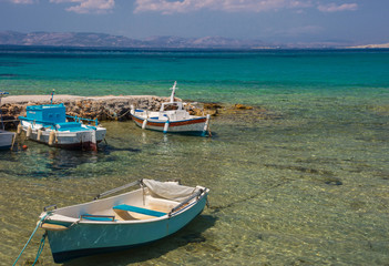 Obraz premium Traditional fishing boats and the clear and blue waters of Mediterranean sea in the Saronic gulf, Greece.