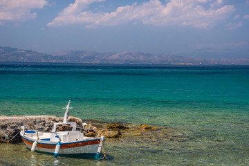 Fototapeta na wymiar Traditional fishing boat and the clear and blue waters of Mediterranean sea in the Saronic gulf, Greece.