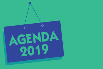 Writing note showing Agenda 2019. Business photo showcasing list of activities in order which they are to be taken up Blue board wall message communication open close sign green background