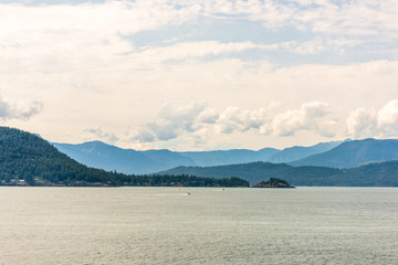 View over Inlet, ocean and island with boat and mountains in beautiful British Columbia. Canada.