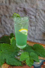 glass of lemonade with cold lemonade with fresh mint leaves and lime with ice cubes with a slice of lemon. Food photography