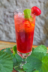 Red Cocktail with Cherry with raspberries and lime on a wooden board