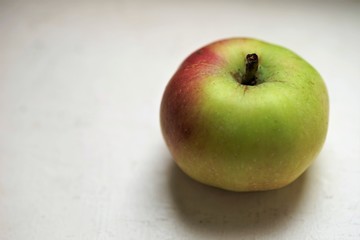 small green apple on the white table