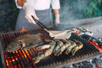 Seafood on the grill. Mussels, shrimp, squid and fish are cooked on fire.