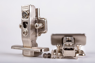 Furniture hinges on a white table. Furniture accessories for carpenters.