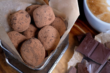 Homemade natural vegan chocolate truffle with cocoa on a white square plate on a white background is sprinkled with fine chocolate chips