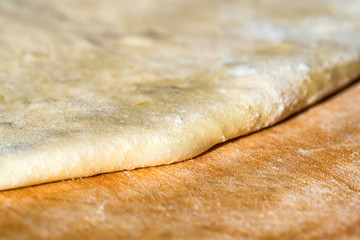 Close up white raw dough on wooden board