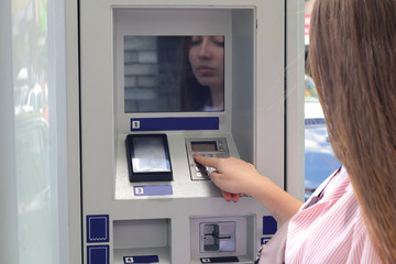Young woman paying for parking outdoors