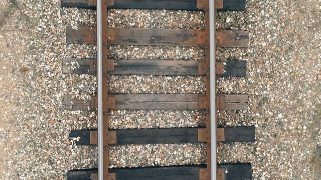 Flying over old rails with wooden sleepers closeup