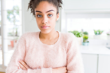 Beautiful young african american woman with afro hair Relaxed with serious expression on face. Simple and natural with crossed arms