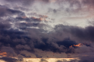 Dark rain clouds during sunset. Dramatic sky during sunset. Dark storm clouds with black and white highlights.