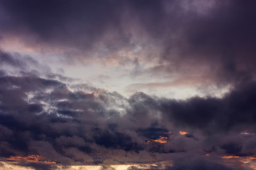 Dark rain clouds during sunset. Dramatic sky during sunset. Dark storm clouds with black and white highlights.