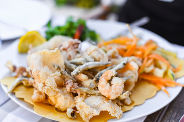 Fried seafood mix. Seafood lunch at the restaurant. Traditional italian food. Shrimp, squid and deep-fried small fish.