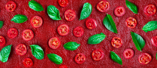Seamless pizza ingredients pattern. Tomatoes and basil on a red tomato sauce. Flat lay