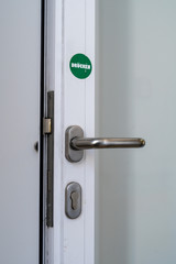 Eine Tür mit einem grünen Punkt mit der Aufschrift Drücken