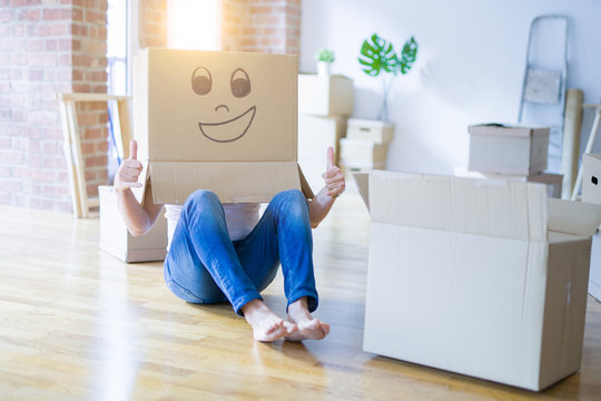 Man wearing funny cardboard box with happy face, moving to a new house, crazy and creative concept