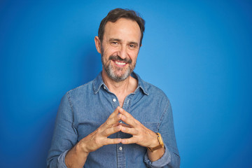 Handsome middle age senior man with grey hair over isolated blue background Hands together and fingers crossed smiling relaxed and cheerful. Success and optimistic