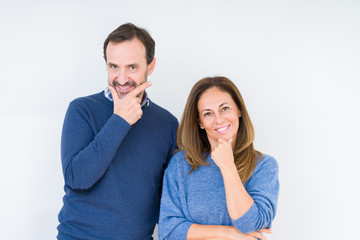 Beautiful middle age couple in love over isolated background looking confident at the camera with smile with crossed arms and hand raised on chin. Thinking positive.