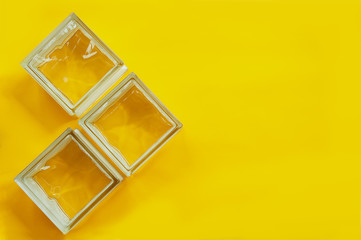 three glass blocks on yellow background with space for text
