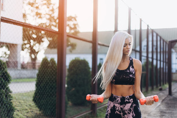 Sport girl training outdoors, workout, exercise concept. Young blondie beauty sexy fitness caucasian girl outdoors with sport equipment. Healthy active lifestyle, sporty body concept