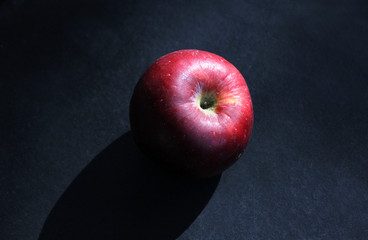 red apple in the sun contrast color on a black