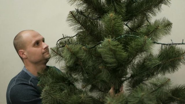 Happy family decorating a Christmas tree with boubles in the living-room