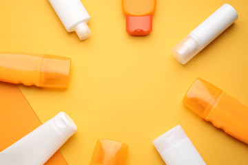 Different sun protection creams on color background