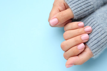 Hands of woman with beautiful manicure on color background