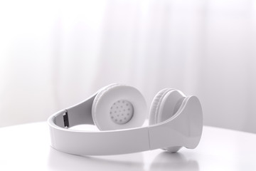 Modern headphones on table in room