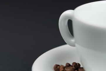 Fototapeta premium White cup of coffee and coffee beans isolated on black background
