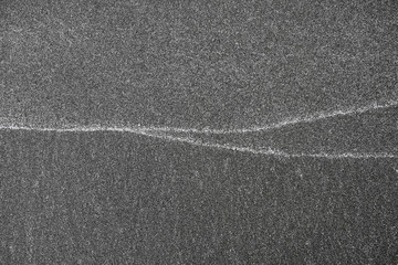 Fototapeta premium Lines on sand, white patterns left by waves on the beach.