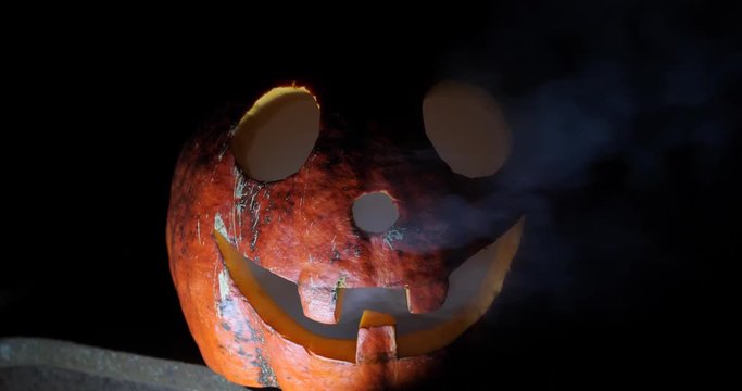 Crazy funny jack pumpkin on halloween close-up in the dark
