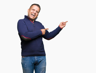 Middle age arab man over isolated background amazed and smiling to the camera while presenting with hand and pointing with finger.