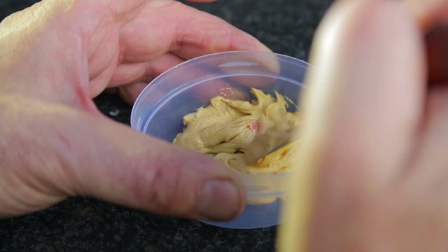 A man dilutes the putty on the metal hardener and mixes it