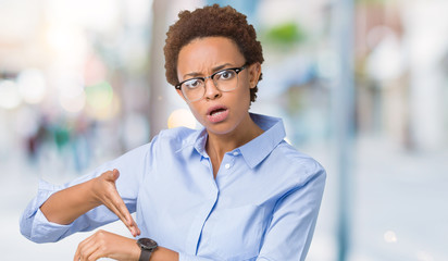 Young beautiful african american business woman over isolated background In hurry pointing to watch...