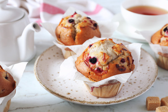 Two blueberry muffins, cup of tea for sweet breakfast