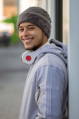 Smiling young latin man sports training with headphones portrait format