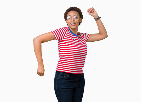 Beautiful young african american woman wearing glasses over isolated background Dancing happy and cheerful, smiling moving casual and confident listening to music