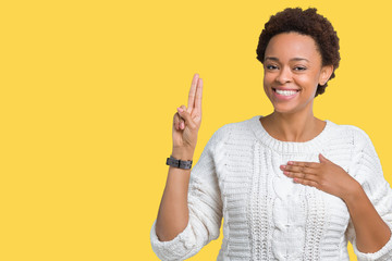 Beautiful young african american woman wearing sweater over isolated background Swearing with hand...