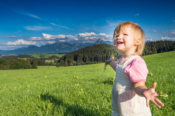 Germany, Bavaria, Allgaeu, happy baby girl playing in the fields