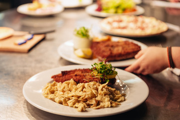 Food orders on the kitchen table in the restaurant, Spätzle noodles with Schnitzel, traditional german meal