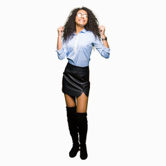 Fototapeta premium Young beautiful business girl with curly hair wearing glasses excited for success with arms raised celebrating victory smiling. Winner concept.