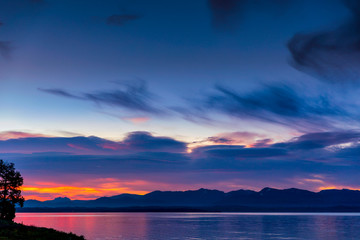 Fototapeta premium Sunrise Above the Lake with Silhouetted Mountains