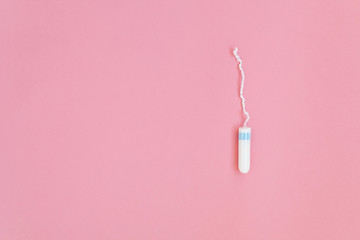 Medical female tampon on a pink background. Hygienic white tampon for women. Cotton swab