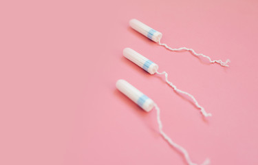 Medical female tampon on a pink background. Hygienic white tampon for women. Cotton swab