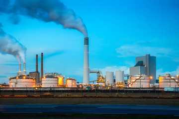 Oil refinery industry at night in Rotterdam, Netherlands. Pollution smoke from oil refinery industry use for environment industry concept.