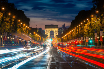 Naklejka na ściany i meble Night scence illuminations traffic street of the Impressive Arc de Triomphe Paris along the famous tree lined Avenue des Champs-Elysees in Paris, France.